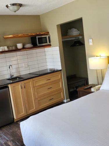 a kitchen with a sink, stove, microwave and refrigerator at Alpine Inn & Suites in Nelson