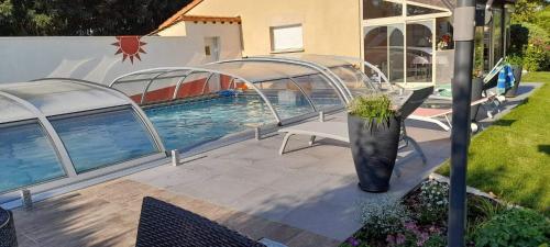 a swimming pool with a black vase next to a house at Le PATSA de Vouillé in Vouillé