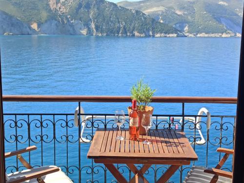 a table on a balcony with a view of the water at Panorama Apartments in Asos