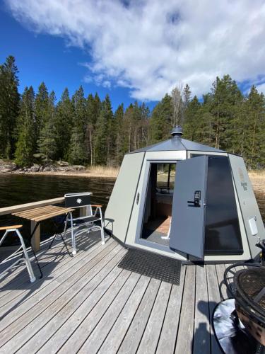 a cabin on a boat with a table on a dock at Yggdrasil Igloo Värmland in Töcksfors