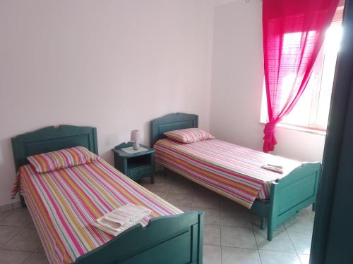 a room with two beds and a window at MaRo Apartment in Cala Liberotto