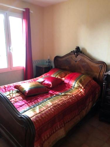 1 dormitorio con 1 cama con cabecero de madera y ventana en Domaine Sagittaires, en Le Cannet-des-Maures