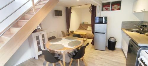 une cuisine et une salle à manger avec une table et des chaises dans l'établissement Les Althéas, à Villers-sur-Mer