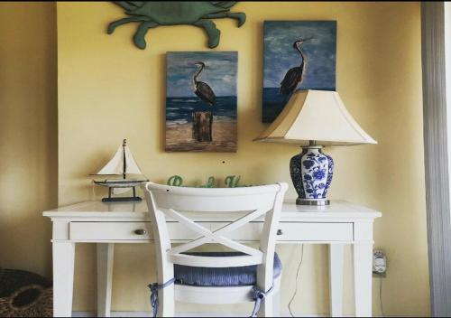 a desk with a chair and a lamp on it at Beach bungalow at Ocean Village in Fort Pierce