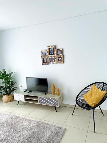 a living room with a tv and a chair at Sónia`s Apart in Nazaré