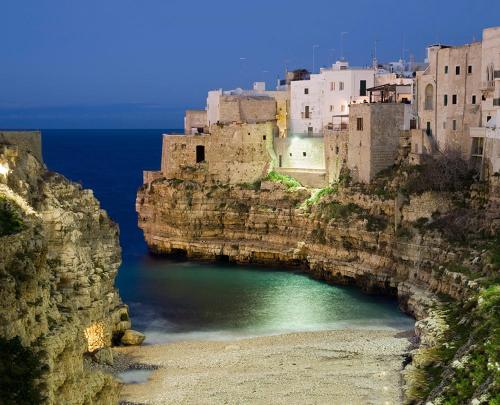 a group of buildings on the side of a cliff at La Casetta di Erasmina in Castellana Grotte