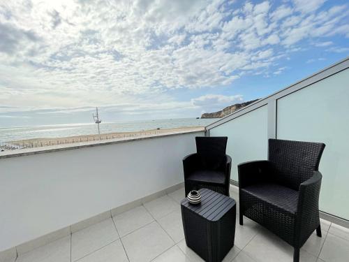two chairs on a balcony with a view of the ocean at Sónia`s Apart in Nazaré