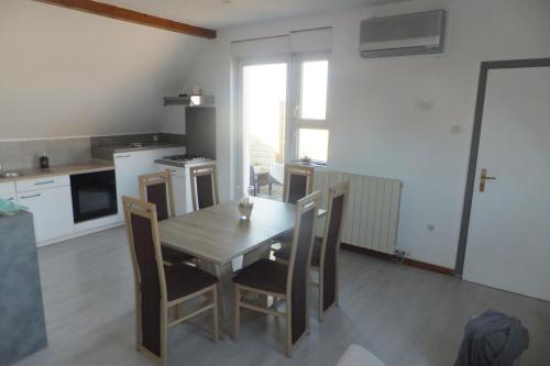 - une cuisine avec une table et des chaises en bois dans la chambre dans l'établissement Superbe appartement en résidence, à Oberbetschdorf