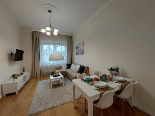 salon ze stołem i kanapą w obiekcie Alföldi Palace Apartman w Debreczynie