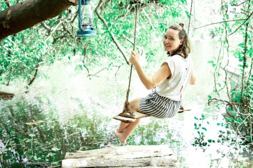 Ein Mädchen, das auf einer Seilschaukel im Wald schwebt in der Unterkunft Wilpattu Green Cabin in Achchamulai
