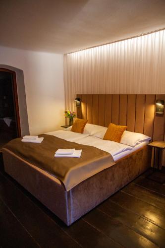 a large bed in a hotel room with towels on it at Hotel Svambersky dum in Český Krumlov
