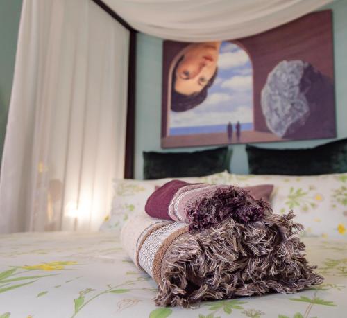 un montón de mantas sentadas encima de una cama en Wunderkammer Art Gallery Home Catania, en Catania
