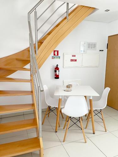 a dining room with a staircase and a table and chairs at Sónia`s Apart in Nazaré