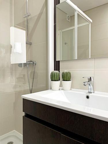 a bathroom with a sink with two potted plants on it at Sónia`s Apart in Nazaré