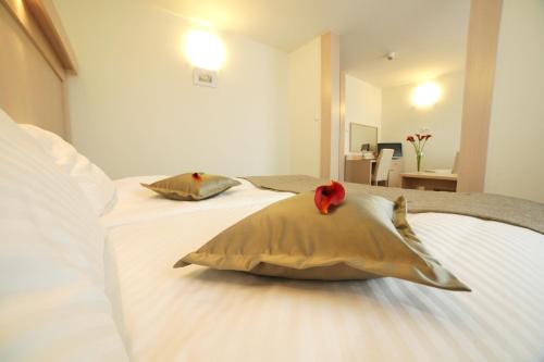 ein Schlafzimmer mit einem Bett mit zwei Kissen darauf in der Unterkunft Hotel Cieplice MEDI & SPA in Jelenia Góra