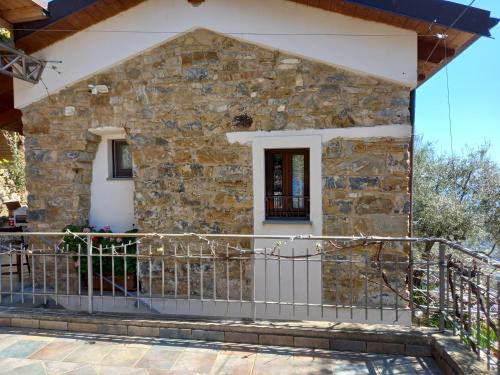 a stone house with a fence in front of it at La casa di Elda in Sanremo
