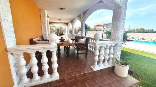 une terrasse couverte avec une balustrade blanche et une table dans l'établissement Apartments Vukancic, à Novigrad