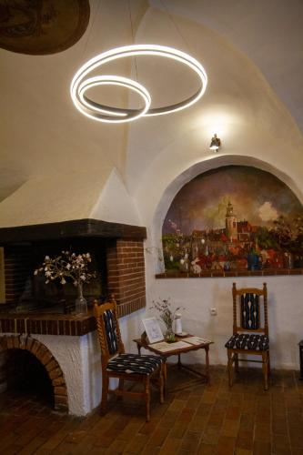 a living room with a fireplace and a chandelier at Hotel Svambersky dum in Český Krumlov