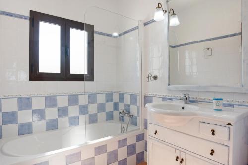 a bathroom with a tub and a sink and a mirror at El Huerto - Sólo Familias in Roche
