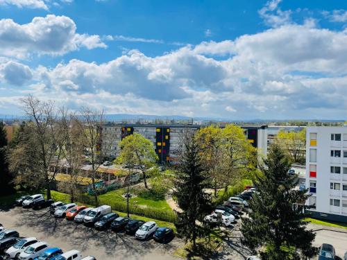 a parking lot with cars parked in front of a building at SunnyF2- EuroAiport-Basel-TrainStation-CityCenter in Saint-Louis