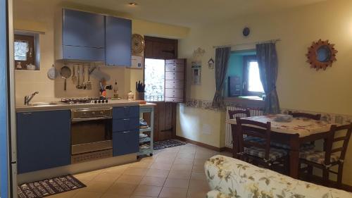 una cocina con armarios azules y una mesa en una habitación en Casa Serendipity, en Vercana