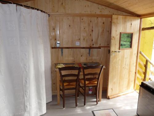 a dining room with two chairs and a table at CABANE perchée dans les arbres in Robion en Luberon