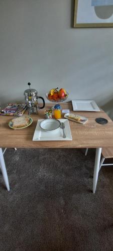 Una mesa de madera con un fregadero y fruta encima. en Tui Glade Bed and Breakfast, en Cambridge