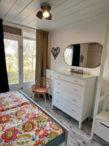 a bedroom with a bed and a dresser and a mirror at Vakantiehuisje Martina 26 in Vlissingen