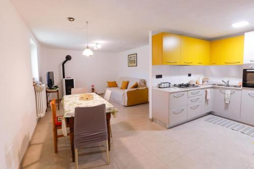 cocina y sala de estar con mesa, cocina y sofá en Accogliente e confortevole appartamento a Doues, en Doues