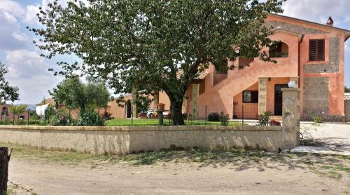 a building with a tree in front of it at Agriturismo Airone in Pitigliano