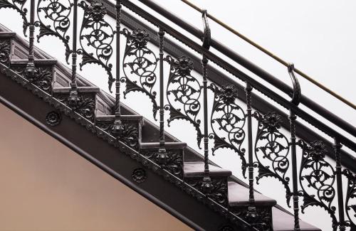 a black staircase with intricate iron railing at The Hotel Chelsea in New York