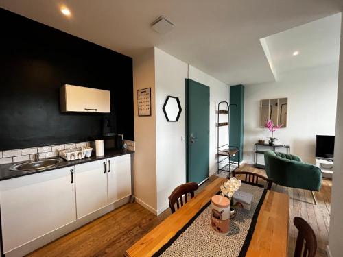 une cuisine et un salon avec une table et des chaises dans l'établissement Charmant T2 bis proche Gare et Centre Ville - Parking proche, à Lourdes