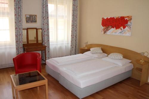 
a bedroom with a bed, chair, and desk at Hotel Graf Stadion in Vienna
