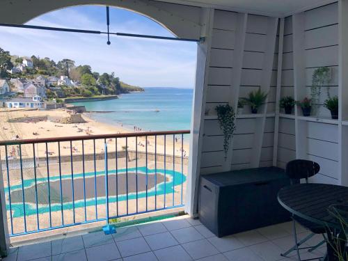 a balcony with a view of a beach and the ocean at Très bel appartement vue mer avec piscine in Douarnenez