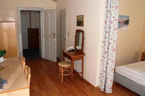 a room with a desk and a mirror and a bed at Hotel Graf Stadion in Vienna