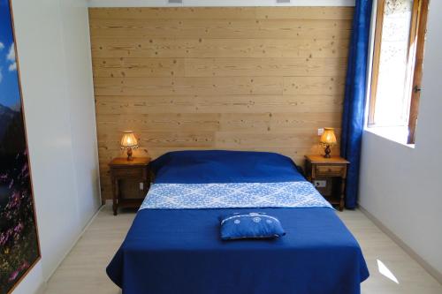 1 dormitorio con 2 camas con sábanas azules y 2 lámparas en Gîte 295 Montagnes du Jura avec Spa et Sauna classé 3 étoiles en Foncine-le-Haut