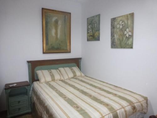 a bedroom with a bed and three pictures on the wall at Vacaciones tierra y mar Casa en el centro con patio y terraza in El Campello