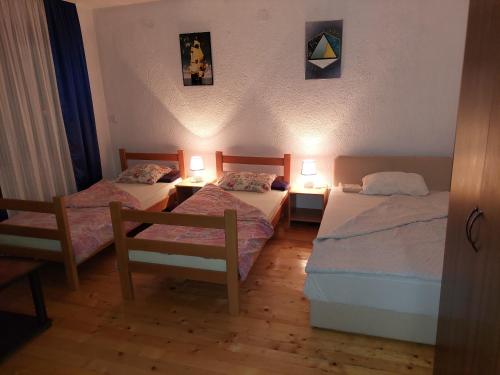 a room with two beds and two tables and two lamps at Mateski guest house in Ohrid