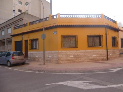 a yellow building on the corner of a street at Vacaciones tierra y mar Casa en el centro con patio y terraza in El Campello