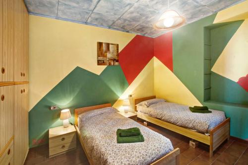two beds in a room with colorful walls at Casa Alan in Gera Lario