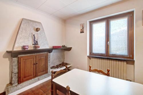 a kitchen with a table and a fireplace at Casa Alan in Gera Lario