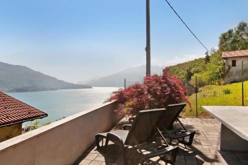 two chairs on a balcony with a view of the water at Casa Alan in Gera Lario