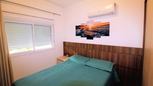 1 dormitorio con 1 cama y una foto en la pared en 1044 - Apartamento de 01 dormitório em Bombinhas - Residencial Egídio Pinheiro 101 B, en Bombinhas