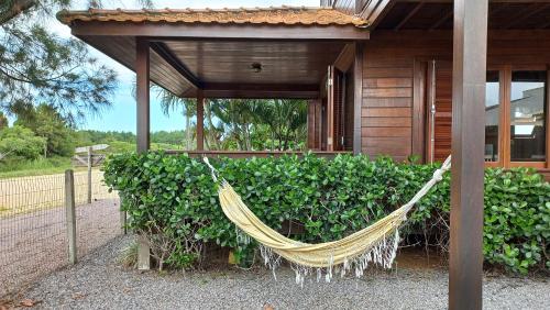 a hammock in front of a building at La Tatuira, Cabana Amarela in Pinheira