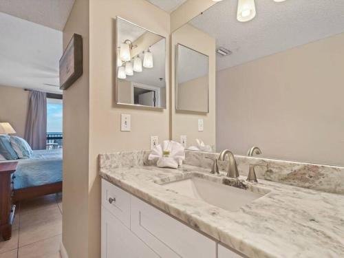 une salle de bain avec un lavabo et un grand miroir dans l'établissement Phoenix VI 6512 - Beachfront w/ Beautiful Ocean Views!, à Orange Beach