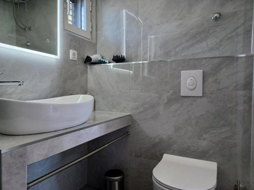 a bathroom with a white sink and a toilet at Olive Stone House in Makarska