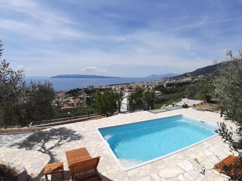a swimming pool with a view of the ocean at Olive Stone House in Makarska