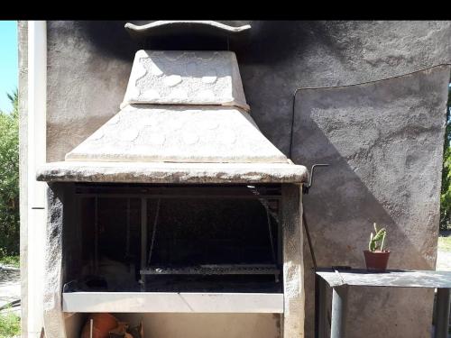 un horno al aire libre con techo y una planta en Duplex "Valle Hermoso" en Malargüe