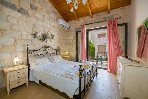 1 dormitorio con cama y pared de piedra en Villa Constancia, en Stalós