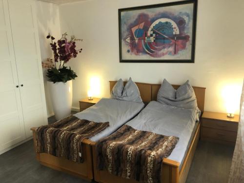 a bed in a room with two tables and a vase with flowers at Appartements Gabat Nähe Red Bull Ring in Sankt Michael in Obersteiermark